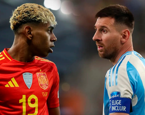 На изображении два футболиста в профиль, один в красной форме сборной Испании с эмблемой, другой в голубой и белой форме. Они смотрят друг на друга на фоне размытых трибун стадиона